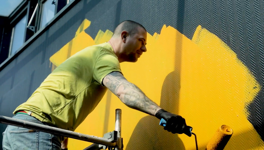 Extrait d'une vidéo de la performance d'Ecloz qui réalise une fresque sur un des murs de la société Trader Services