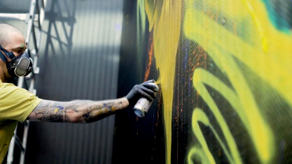 Extrait d'une vidéo de la performance d'Ecloz qui réalise une fresque sur un des murs de la société Trader Services