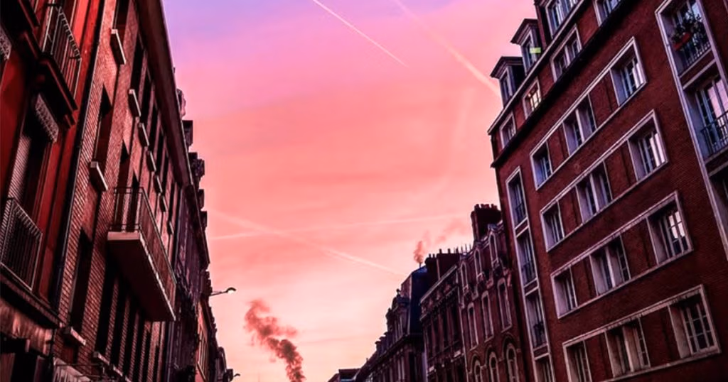 Photo de Rouen montrant des immeuble en brique et un ciel rosé
